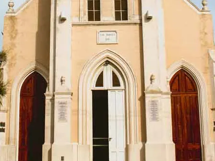 Los tres portales ojivales del frente: dos puertas de madera rojiza a los costados y la puerta principal en la torre
