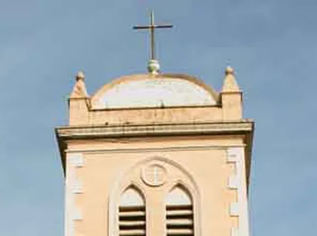 Remate de la torre: pretil con pináculos en las esquinas, cúpula baja y cruz de hierro