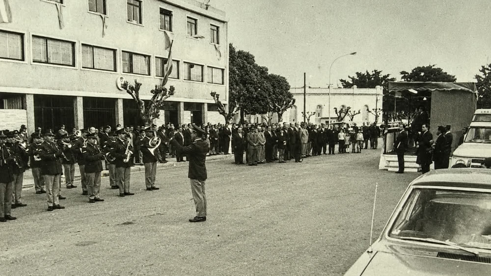 Foto en blanco y negro de 1971: una banda de música uniformada toca frente al nuevo edificio de ENTEL, con vecinos en la vereda y un palco de autoridades